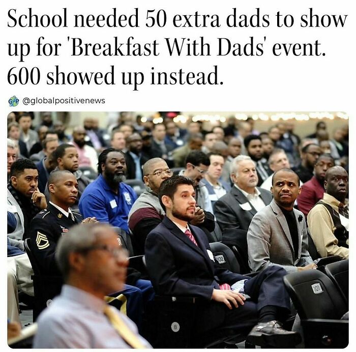 A large group of fathers sitting in an auditorium for the Breakfast With Dads event, showcasing wholesome kindness.