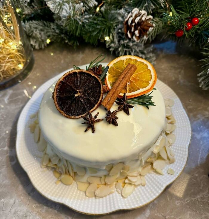 Christmas snack idea: Festive cake with white icing, topped with dried oranges, cinnamon sticks, and star anise.