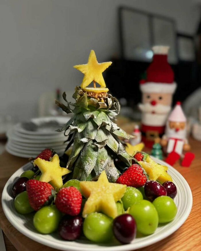 Fruit Christmas tree with pineapple, grapes, strawberries, and star-shaped slices, perfect for festive snack food ideas.