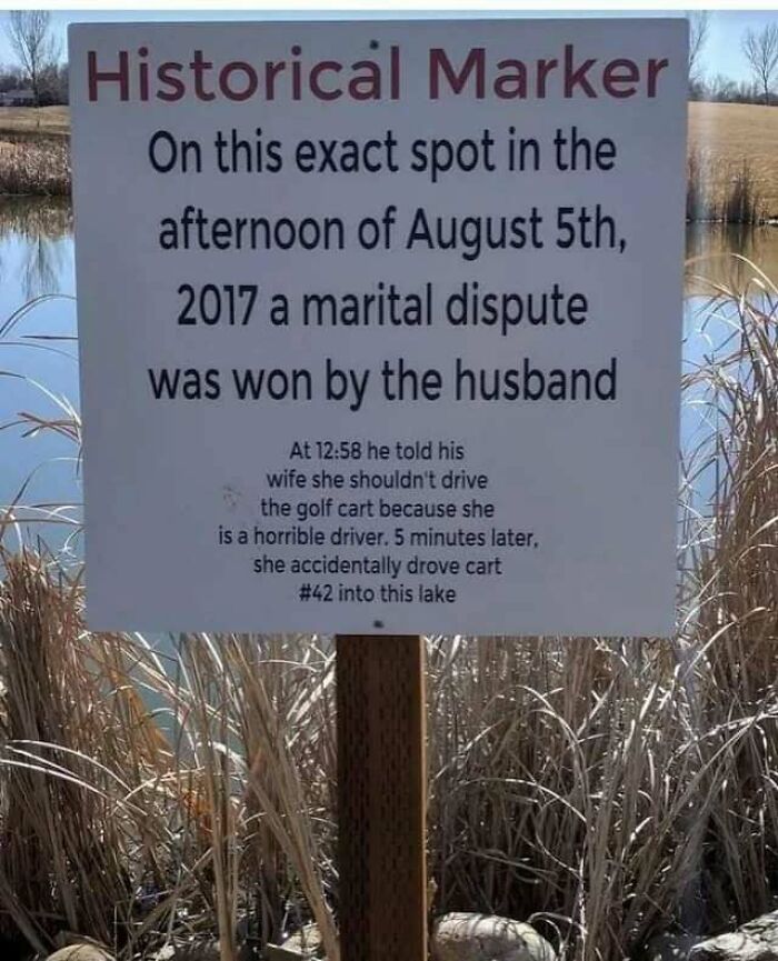 Sign by a lake detailing a funny marital dispute; part of the "Now That's Funny" IG Page's relatable memes collection.