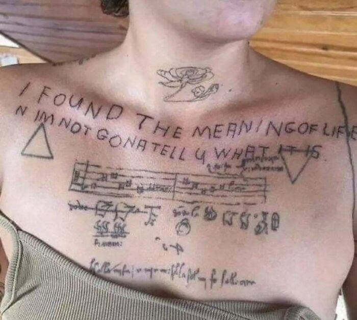 A person with a humorous and mysterious tattoo referencing the meaning of life, highlighting relatable mental health humor.