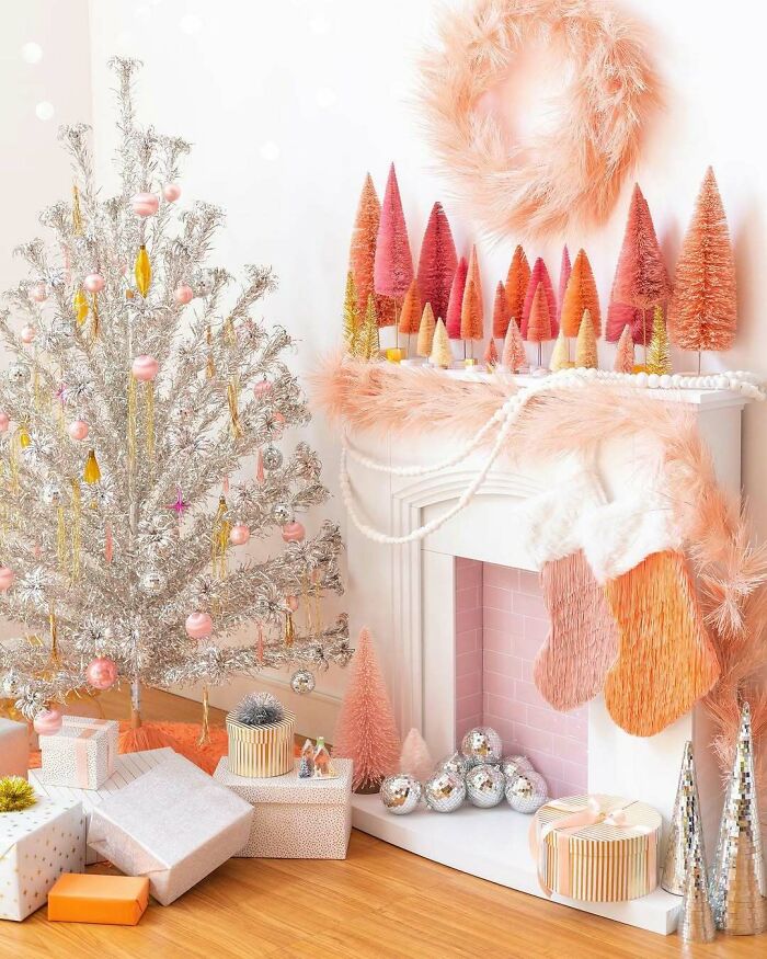 Silver Christmas tree with pink ornaments, surrounded by gifts and decorations, showcasing festive Christmas decorating ideas.