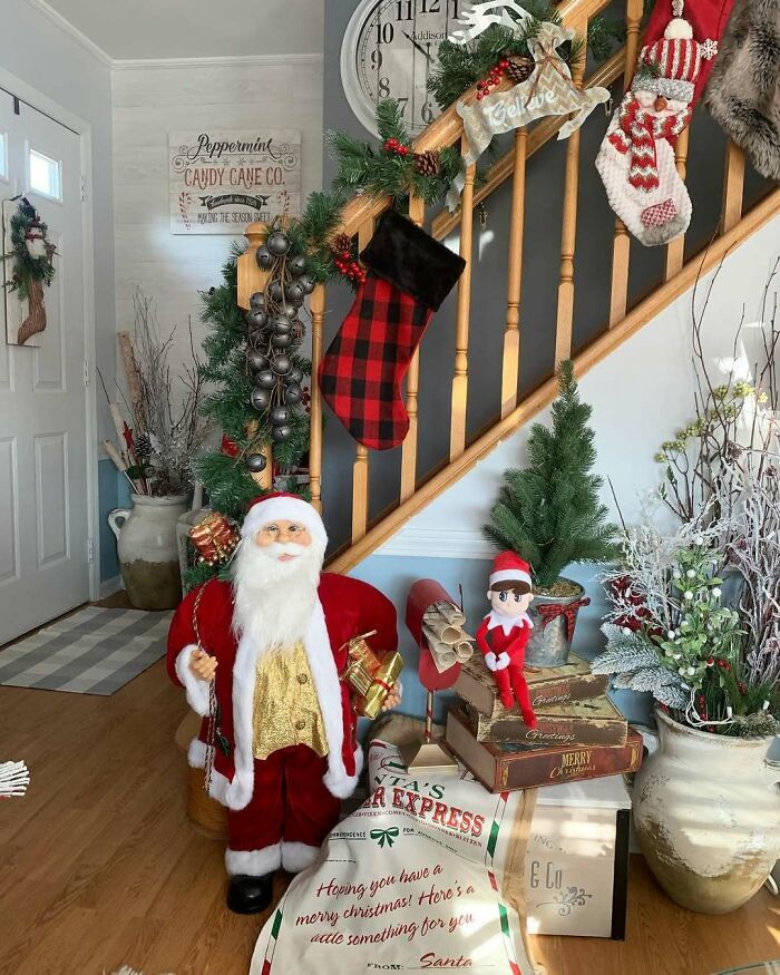 Festive Christmas decorating ideas featuring Santa figure, stockings, and holiday greenery on a staircase.