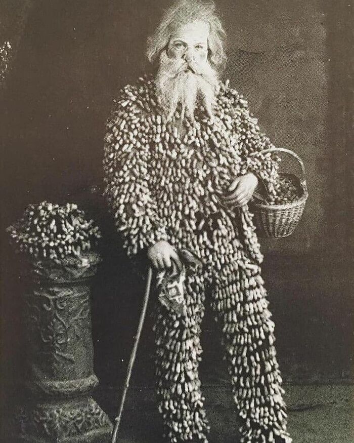 Man in a unique textured suit holding a basket and cane, showcasing historical fashion for shaping the future.