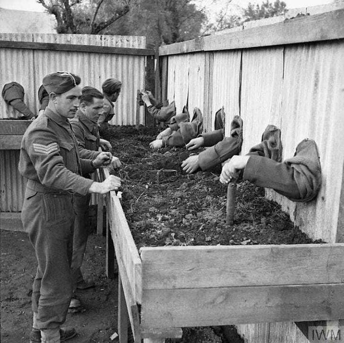 Soldiers practice bomb planting in a training exercise, learning techniques from the past to shape future military tactics.