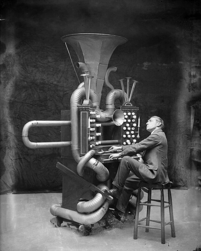 Man playing a vintage machine with pipes and buttons, illustrating the theme "learn from the past" in historical imagery.