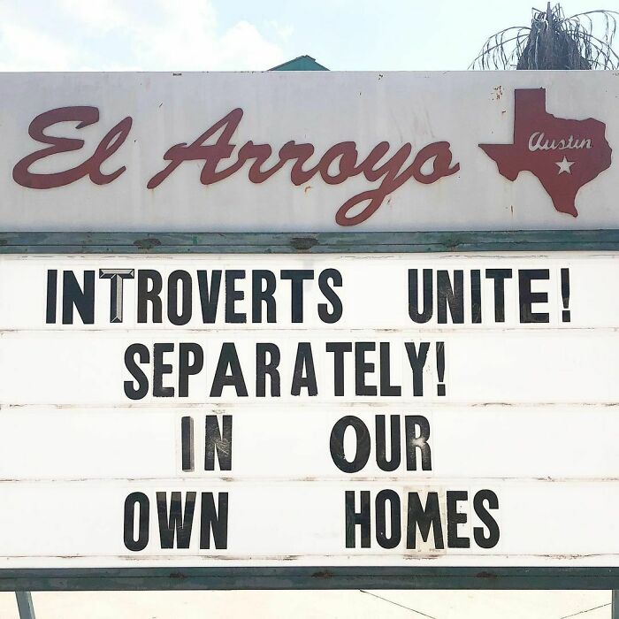 El Arroyo sign reads "Introverts unite! Separately! In our own homes," humorously highlighting introvert lifestyle.