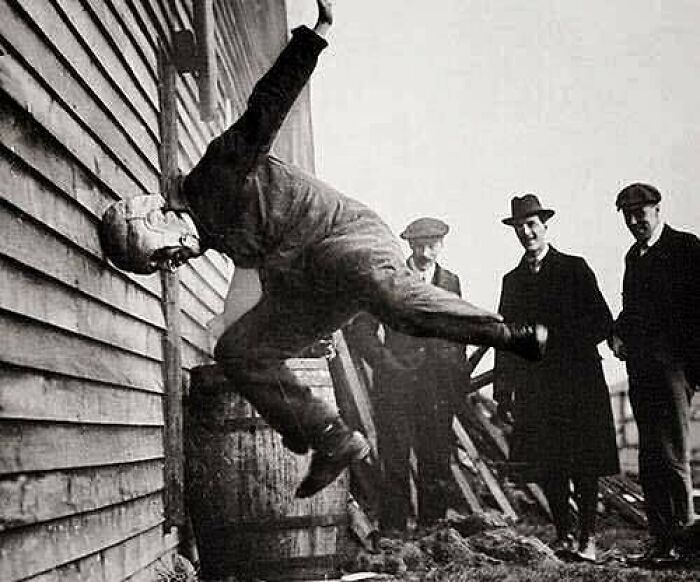 Historic photo of a man testing a bulletproof vest in front of spectators, reflecting innovation from the past.