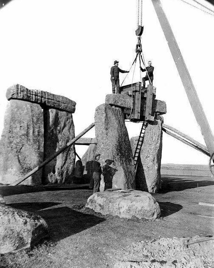 Historical photo of Stonehenge restoration with workers and crane, capturing the past to shape the future.