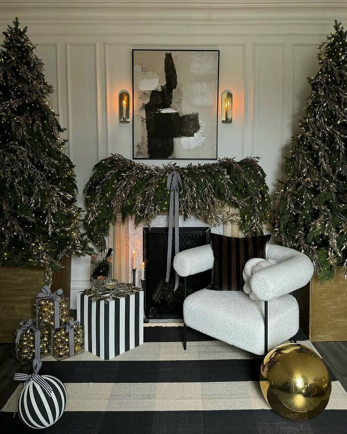 Festive Christmas-decorating-ideas with a modern fireplace, greenery, gold ornaments, and stylish black-and-white accents.