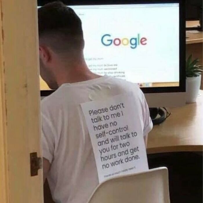 Student sitting at desk with a humorous sign taped to their back, exemplifying university life struggles.