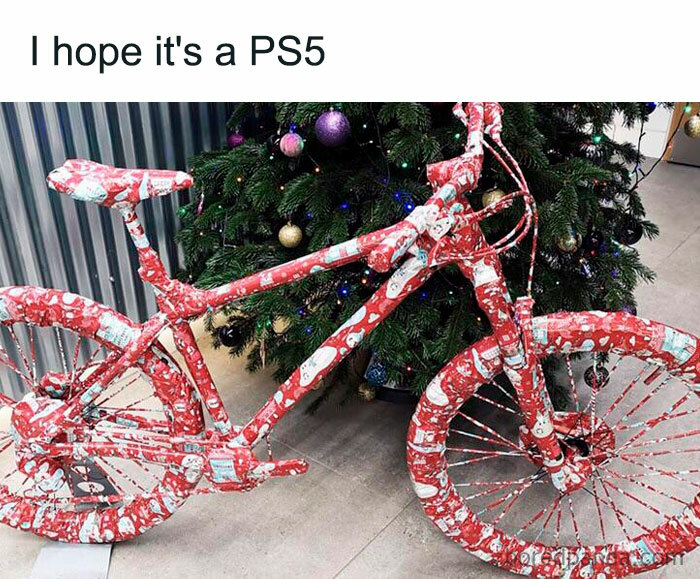 Wrapped bicycle as a Christmas gift in front of a tree, humorously captioned.