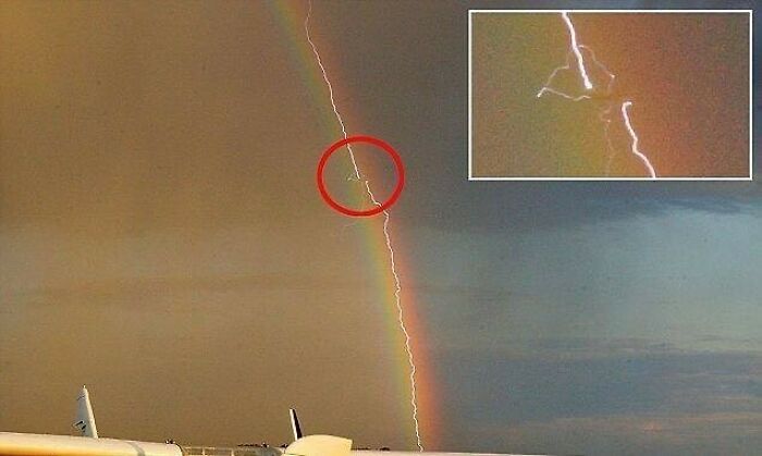 Lightning striking a rainbow over an airport, with an inset highlighting the event.