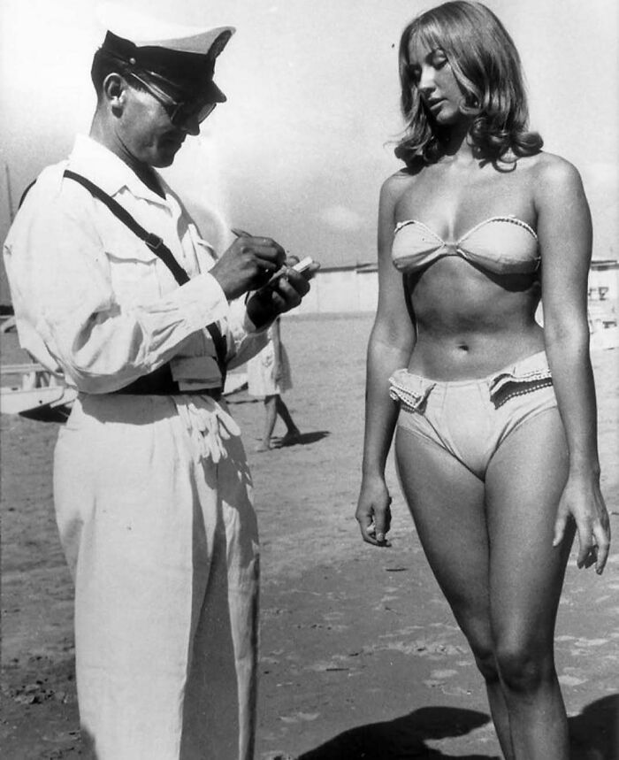 Beach officer writing ticket for woman in bikini, showcasing interesting history facts.