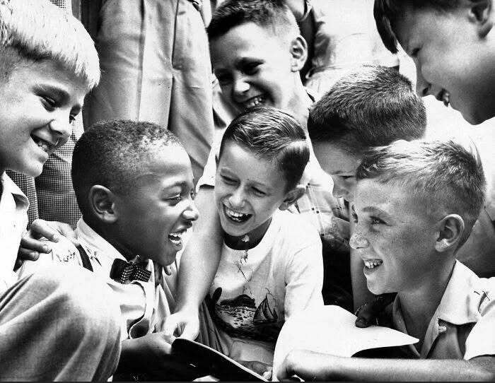 Children smiling and laughing together, representing historical moments shaping the future.