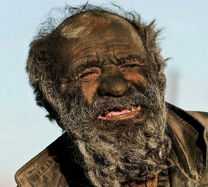 A man with a weathered face and beard, embodying unique historical life experiences.