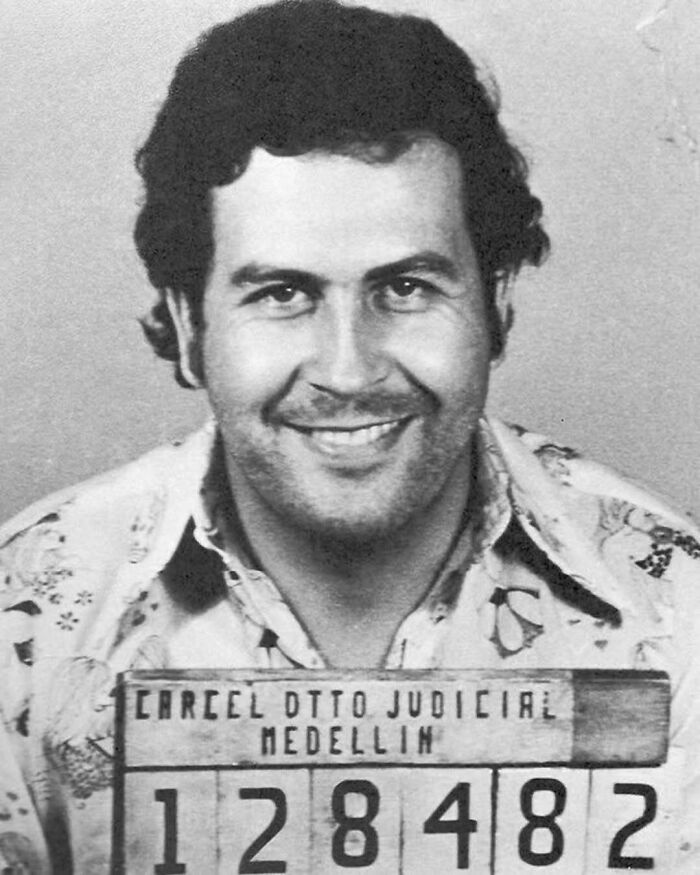 Historical mugshot of a smiling man from Medellin, wearing a patterned shirt.