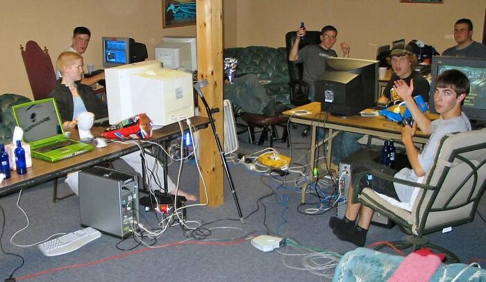 Group of young men in a retro gaming setup with old computers, embodying interesting history pics facts.