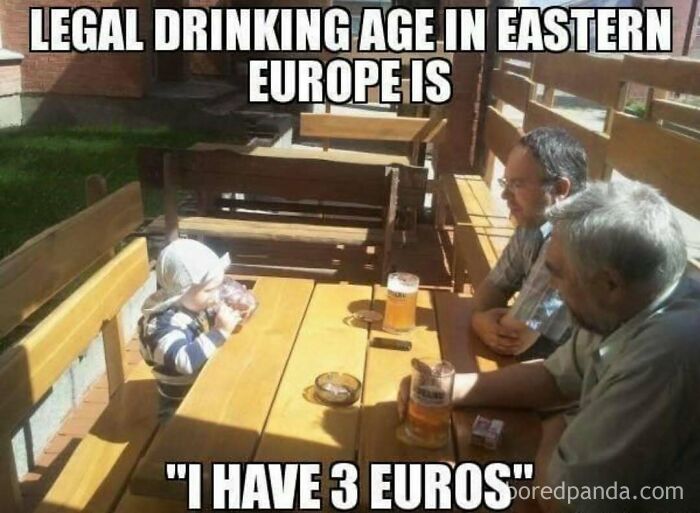 Polish meme showing a toddler with two men at a table, with beers and funny text about the drinking age, in outdoor seating.