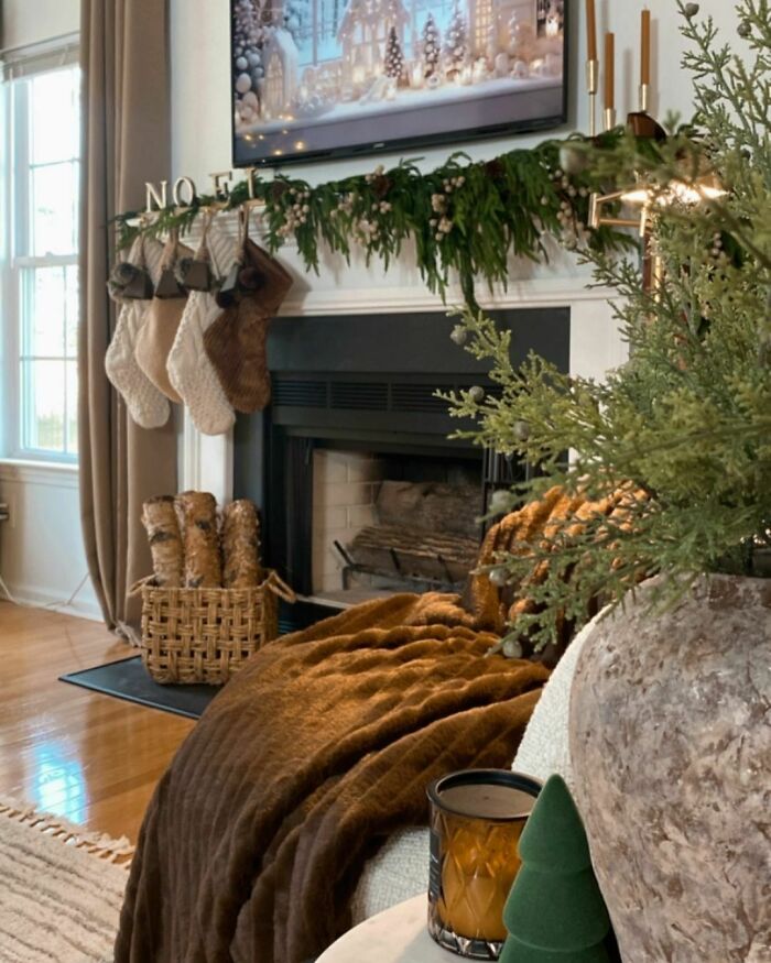 Cozy Christmas-decorating-ideas with garland, stockings, and a warm fireplace setting.