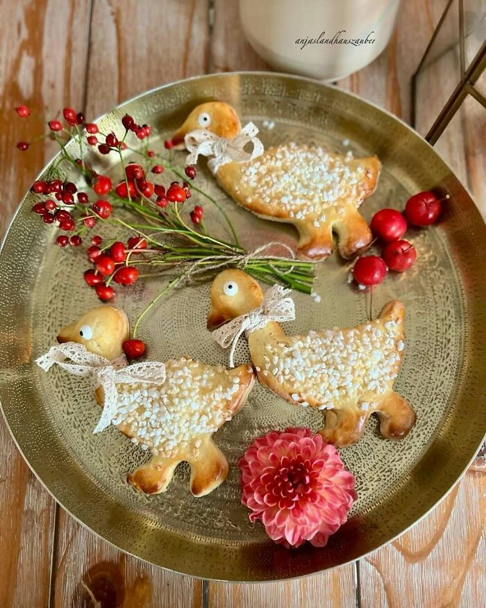 Plate of duck-shaped Christmas snack foods with berries and a pink flower.