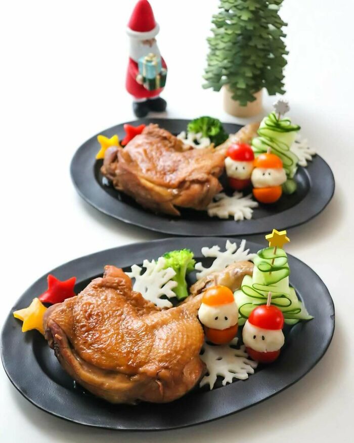 Festive Christmas snack food ideas with chicken, vegetables, and holiday-themed decorations on black plates.