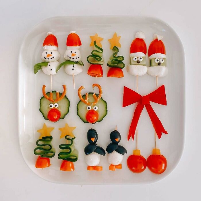 Christmas snack food ideas with festive designs of snowmen, reindeer, and penguins made from vegetables on a platter.