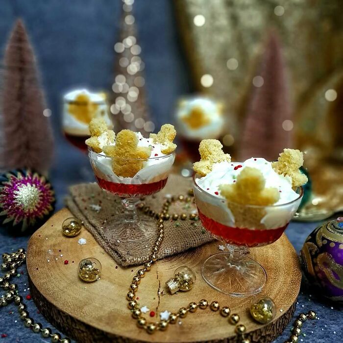 Festive Christmas snacks with gingerbread decorations in glass cups, surrounded by holiday ornaments and decor.