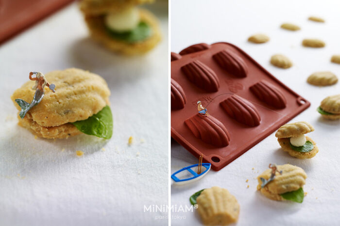 Miniatures of tiny people interacting with food items next to a baking tray, showcasing creative small-scale artistry.