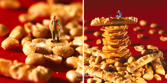 Miniatures of people interacting with stacked crackers and peanuts on a red surface, showcasing creative food art.