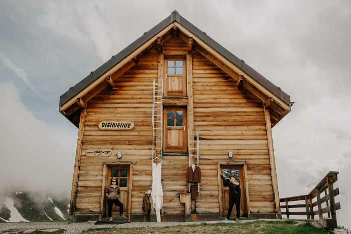 Rustic wooden cabin with wedding attire displayed outside, featuring one of the top wedding photos of 2024.