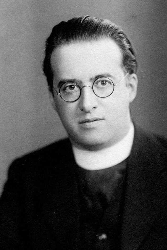 Monochrome portrait of a man in glasses and formal attire, potentially linked to influential historical moments.