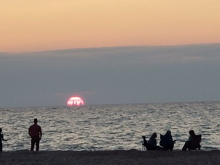 Silhouettes on the beach at sunset, capturing rare everyday facts of nature's beauty.