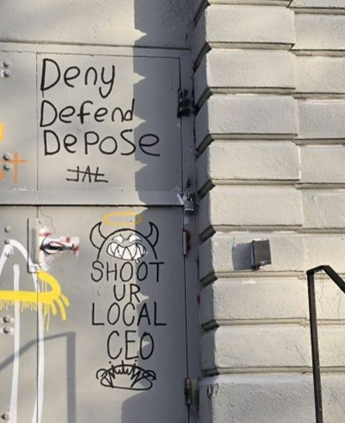 Graffiti on a wall with slogans including "Shoot Ur Local CEO" and "Deny Defend Depose.