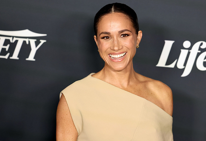 Smiling Meghan Markle in an elegant dress at Variety event.