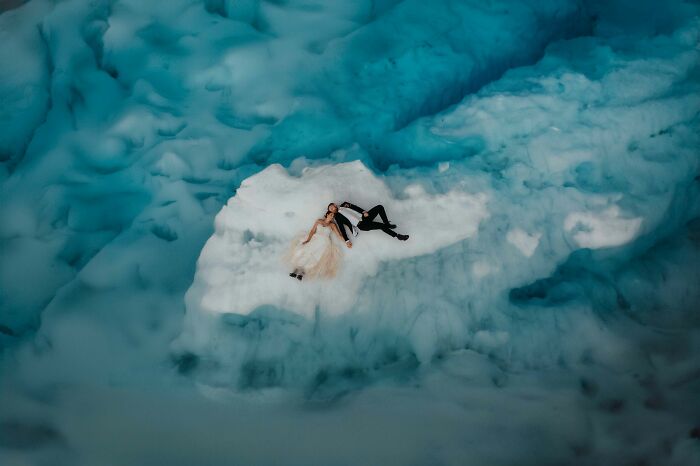 Bride and groom lying on a glacier, captured as one of the top wedding photos of 2024.