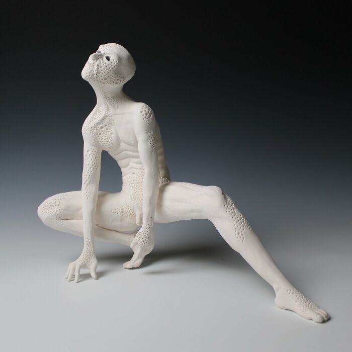 Surreal ceramic sculpture featuring an abstract human form with textured surface, bending in a dynamic pose.