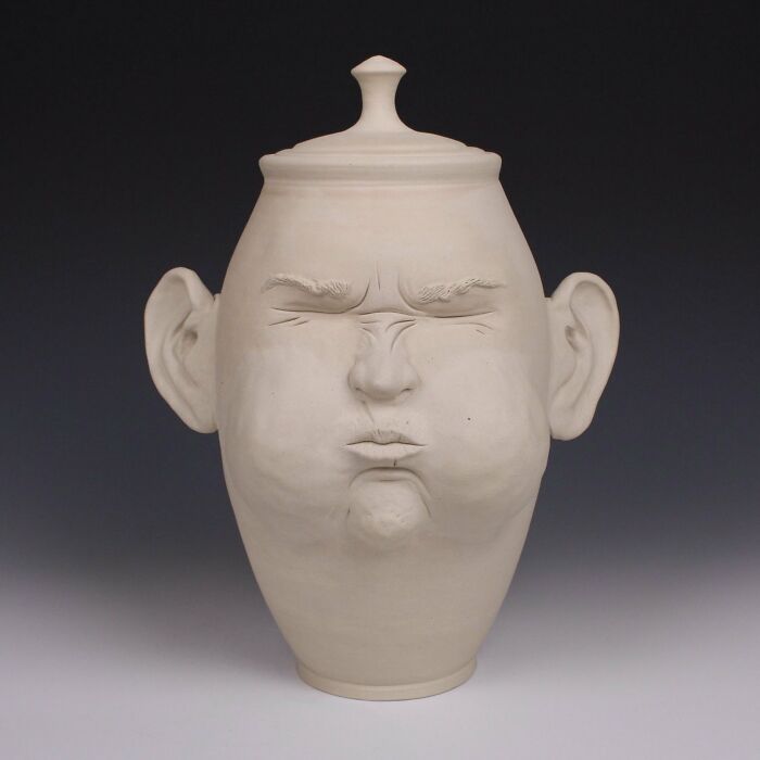 Surreal ceramic art piece by Jackson Shaner with a face displaying a puckered expression.