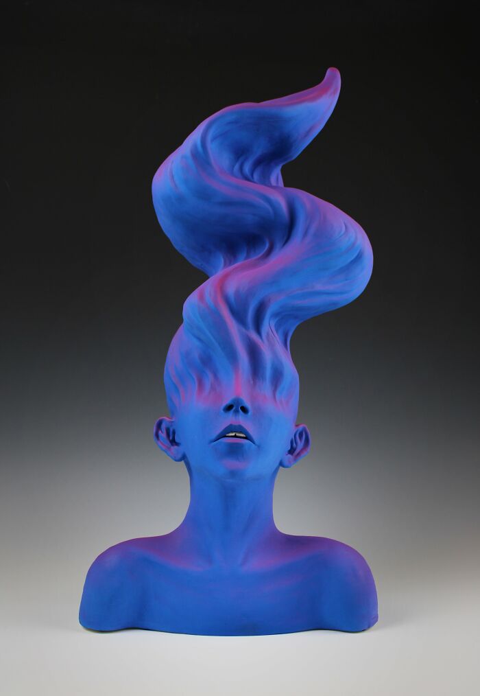 Surreal ceramic art sculpture with a blue and pink face and flowing hair, conveying emotion.