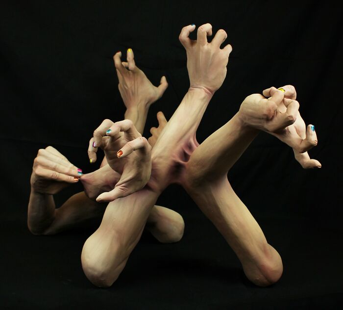 Surreal ceramic art sculpture by Jackson Shaner featuring intertwined hands with painted nails.