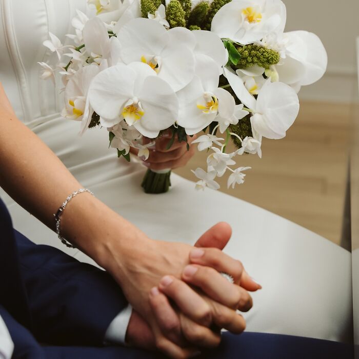 Couple holding hands with a wedding bouquet, symbolizing their unique story after a car accident en route to a photo shoot.