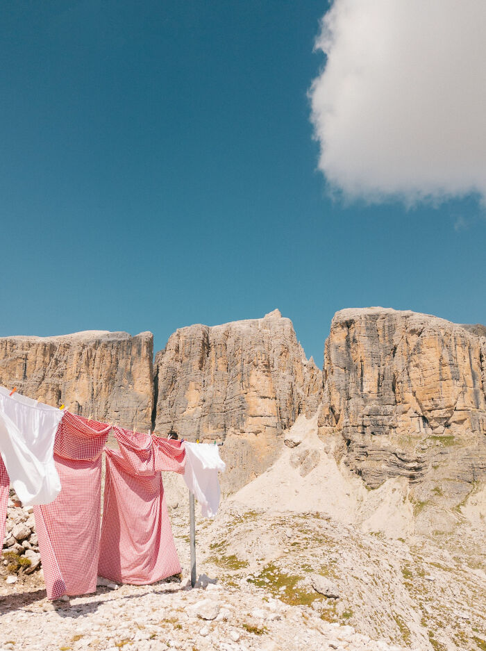 Laundry drying on a clothesline with majestic rocky cliffs in the background under a clear blue sky, Incredible World Photos.