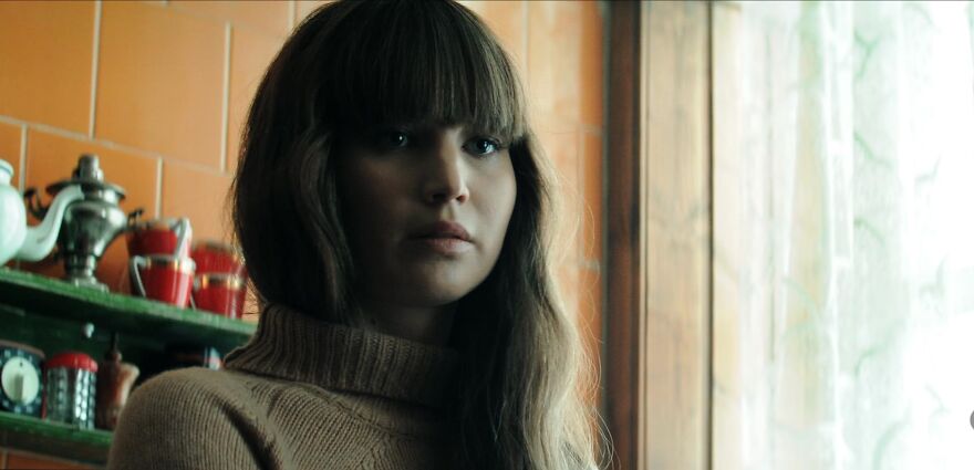 Actress Jennifer Lawrence in a cozy kitchen setting with long hair and a turtleneck, embodying their signature persona.