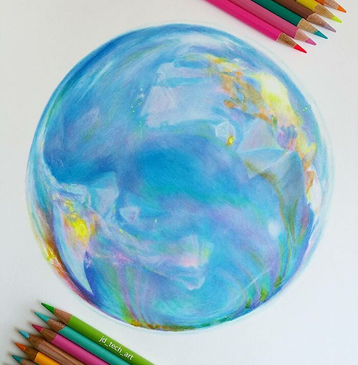 Hyper-realistic pencil drawing of an Earth-like orb with vibrant colors, surrounded by colored pencils.