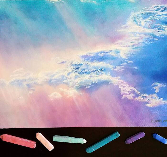 Hyper-realistic pencil drawing of colorful clouds with pastel sticks beneath, showcasing artistic skill.