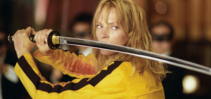 A person in a yellow suit wielding a katana, capturing the essence of fascinating fan theories in cinema.