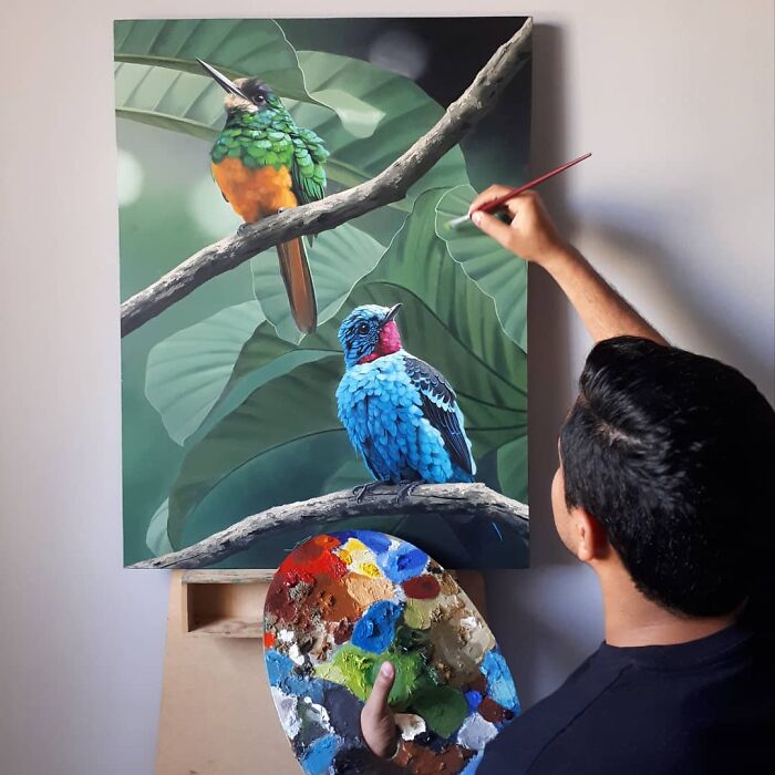 Brazilian artist painting vibrant birds with a palette, transforming feathers into fine art.