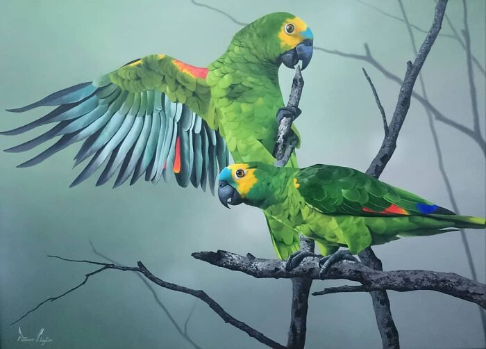 Brazilian artist's vibrant feather art depicting two green parrots on branches against a muted background.