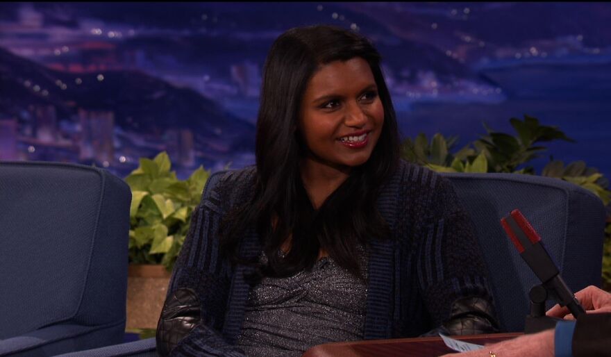 Actress Mindy Kaling on a talk show, smiling, showcasing actors who play themselves theme.