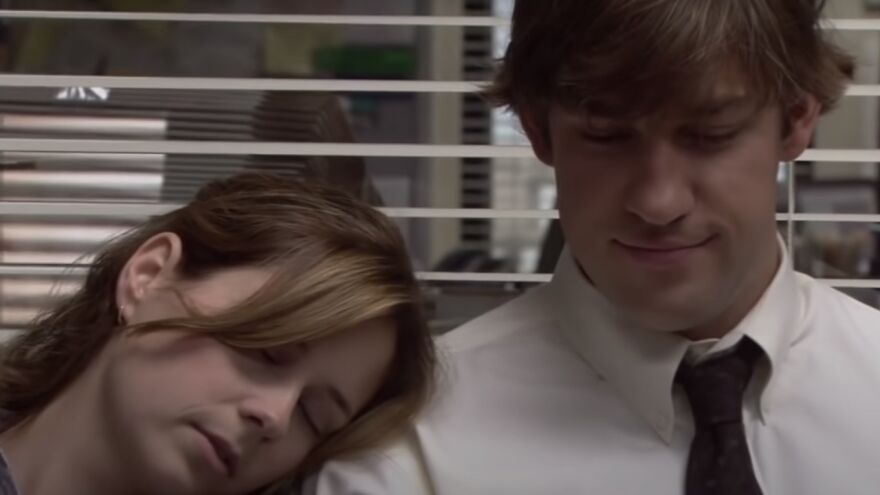 A couple sitting together, displaying a tender moment, relevant to movie couple relationship themes The Office.